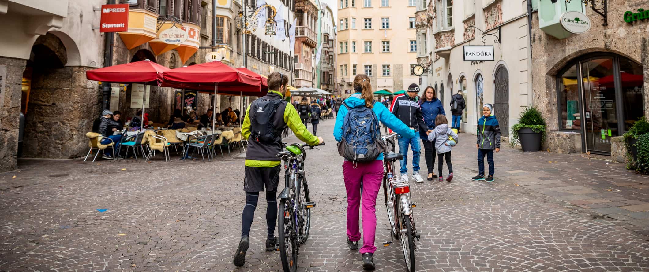 People out and about walking along a narrow old street in charming Austria