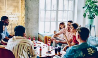 A bunch of backpackers hanging out at a hostel in the common area