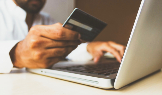 a person using their travel credit card to shop on their laptop