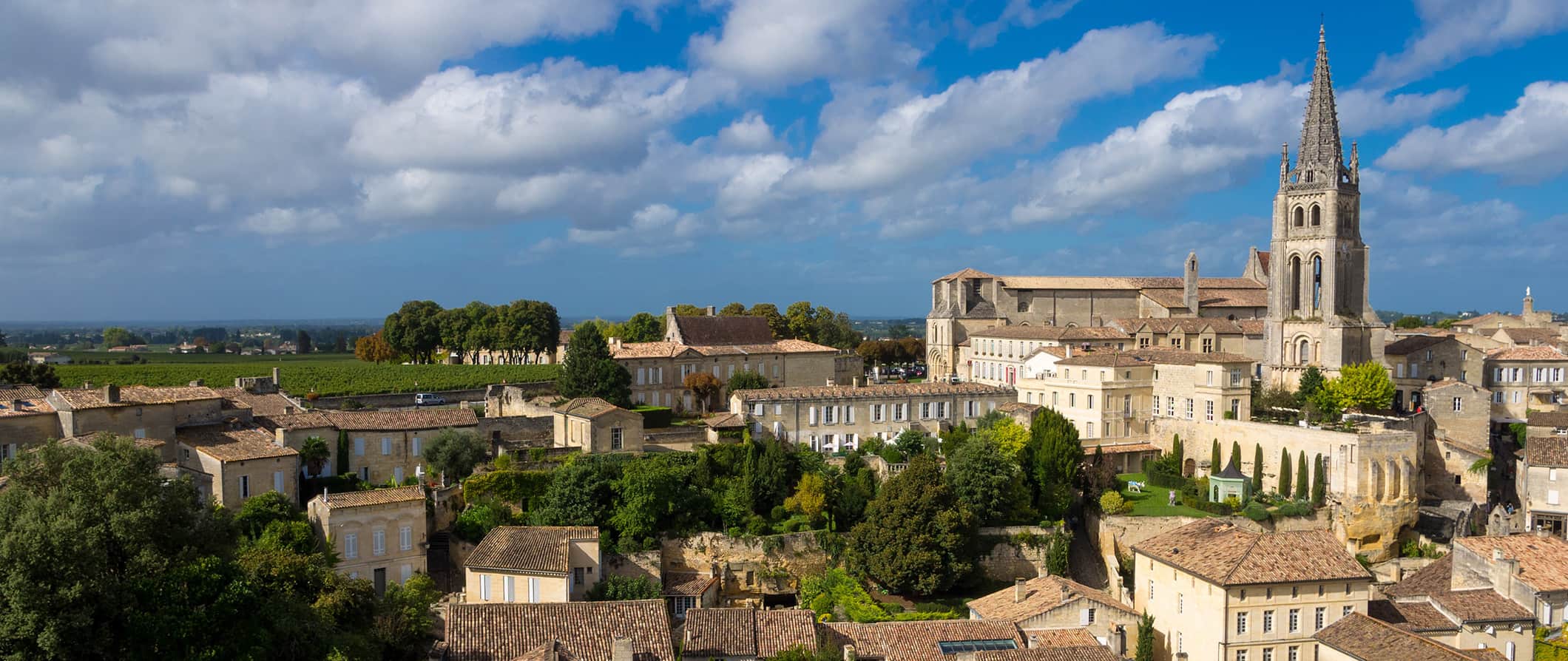 The rooftops and skyline of Bordeaux, France, featuring a towering church in the background on a bright sunny day