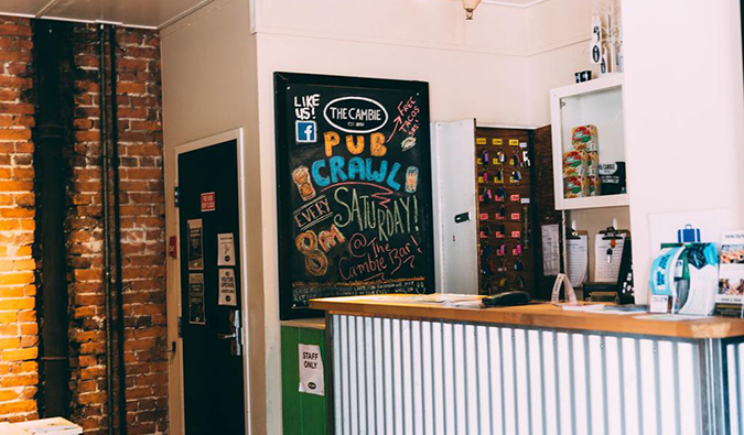 Front desk with blackboard announcing events at Cambie Hostel Seymour in downtown Vancouver.