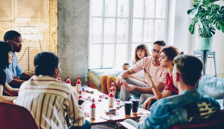 New friends in a hostel playing games and drinking together