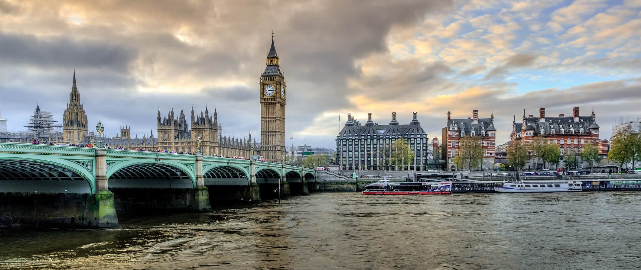 The famous London Bridge on a cloudy day in London, England with historic buildings in the distance and the river in the foreground