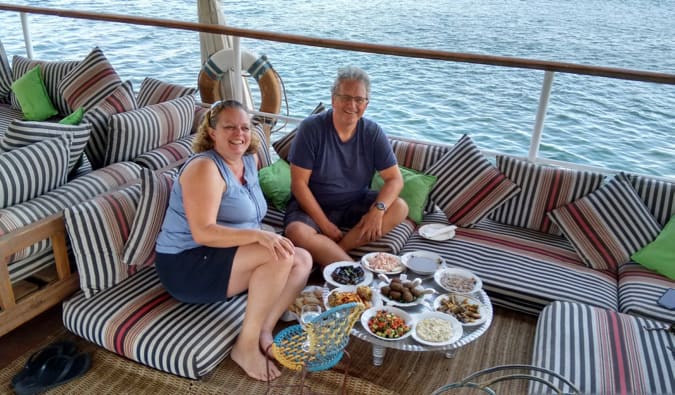 Esther and her husband posing for a photo while on a boat