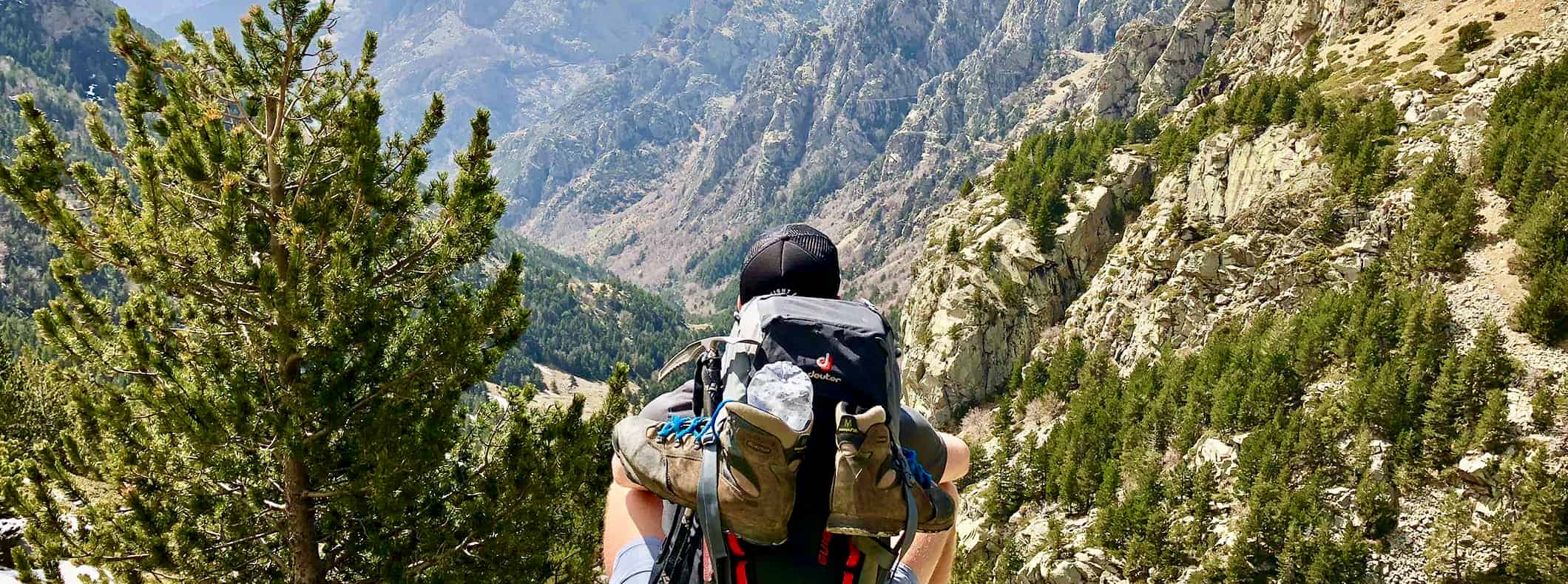 a man wearing hiking gear while hiking over a rugged landscape