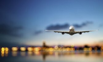 A huge commercial airline coming in to land against a bright blue sky