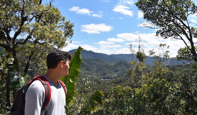 Nomadic Matt looking over his shoulder out to a scenic view of some mountains