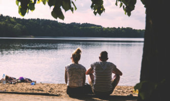 A couple sitting by the lake together