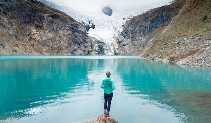 Kristin Addis posing in front of a bright blue lake in the mountains