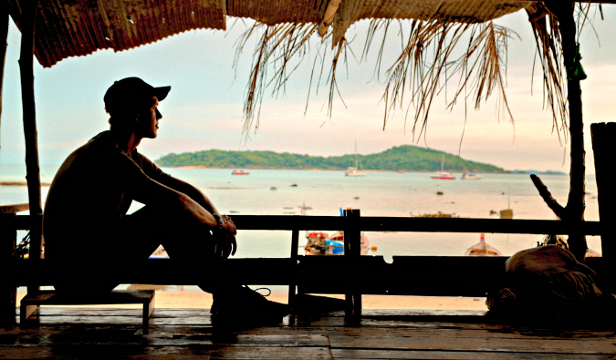 A man sitting near the beach during sunset