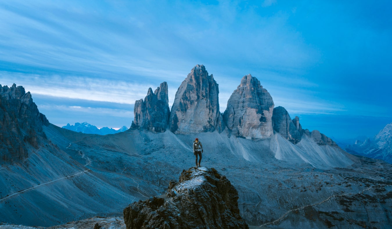 A solo traveler standing on a mountain looking out into the distance