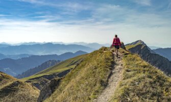 A woman hiking on a sunny day in the rugged mountains