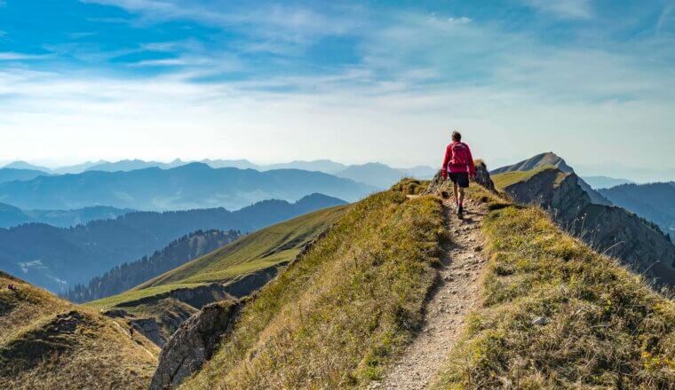 A woman hiking on a sunny day in the rugged mountains