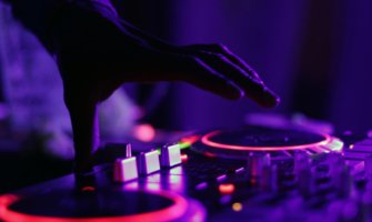 A turntable at a rave with purple lights