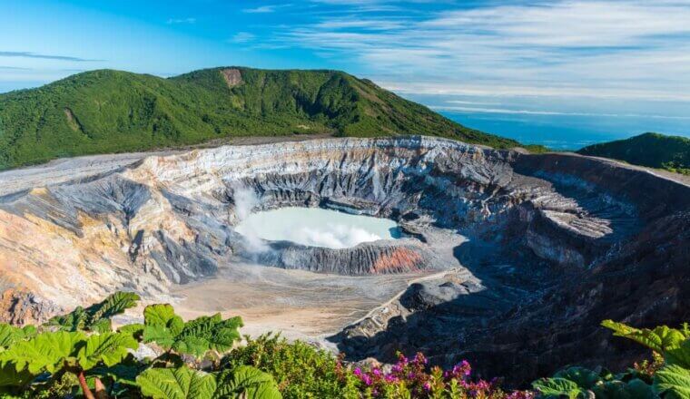 panoramic view of the Poas Volcano with its aquamarine caldera surrounded by rocky cliffs in Costa Rica