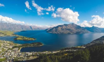 Aerial view of Queenstown, New Zealand, showing the city on the water with mountains in the background