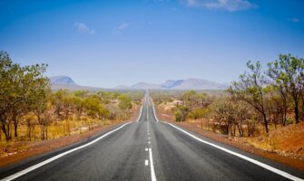 A wide open road in the Outback of Australia on a bright and sunny day