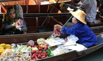 An old woman in Thailand selling food at a market