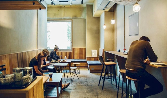 Travelers and customers sitting in the lounge area at the CITAN hostel in Tokyo, Japan