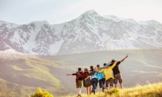 A group of travelers together hiking in the mountains in a rugged area posing for a photo